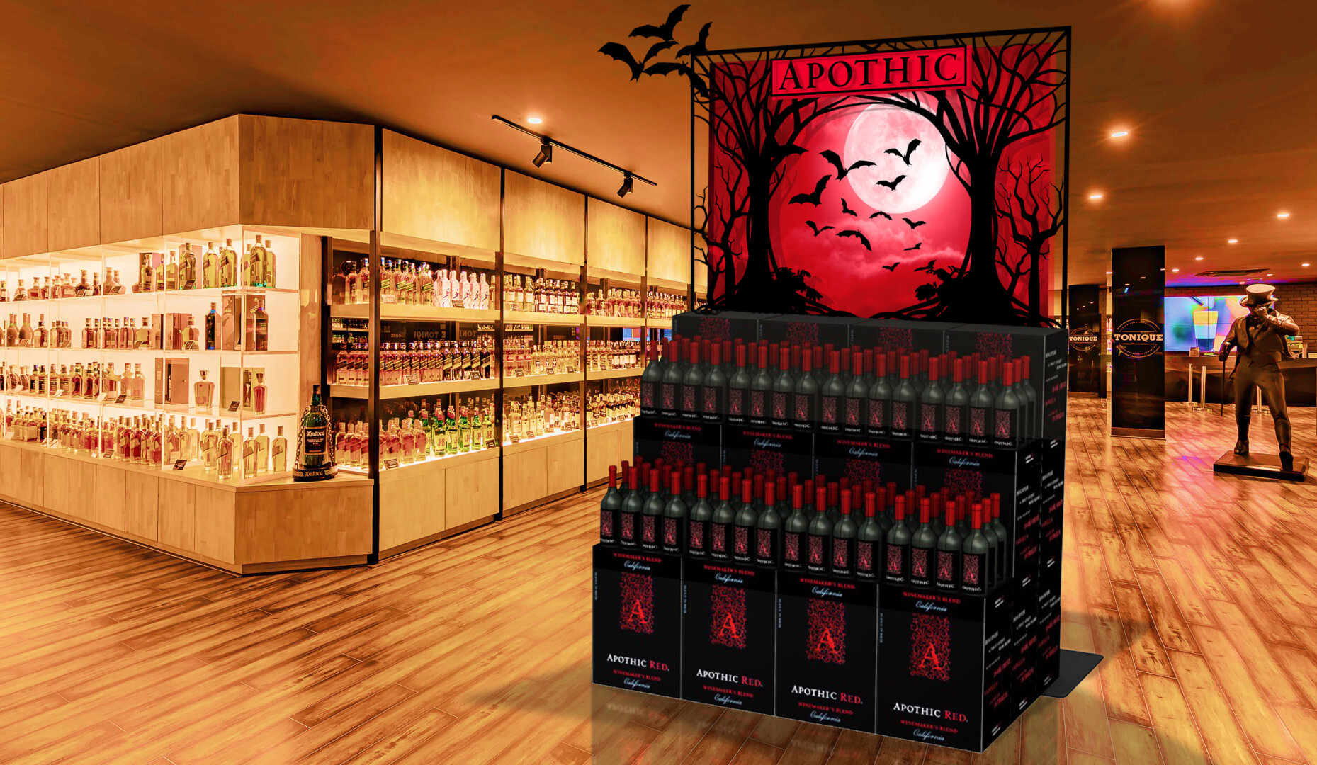 An apothic halloween store display featuring black trees and bats with a red moon in the background. The display is surrounded by cases of wine in a store environment.